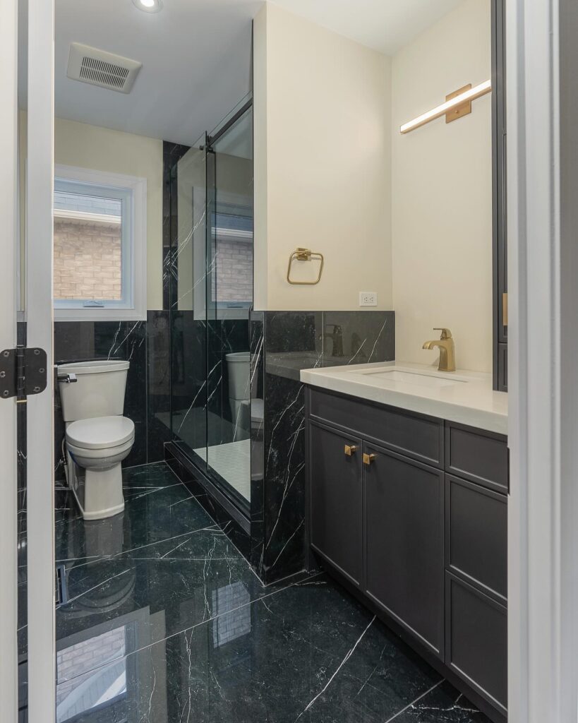 a bathroom with a black marble floor and a white toilet