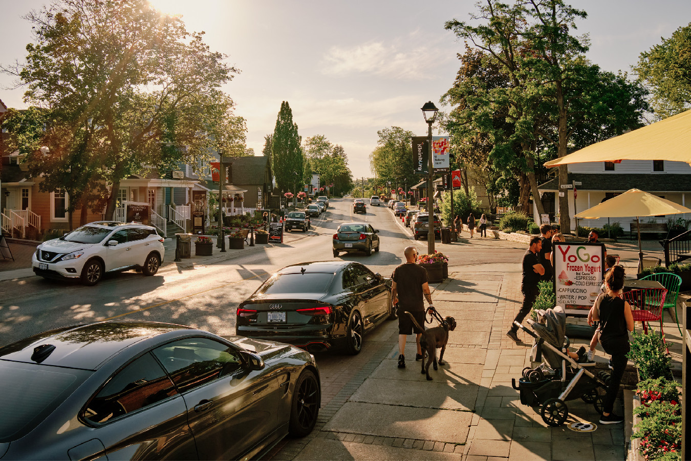 a street with cars and people walking on it