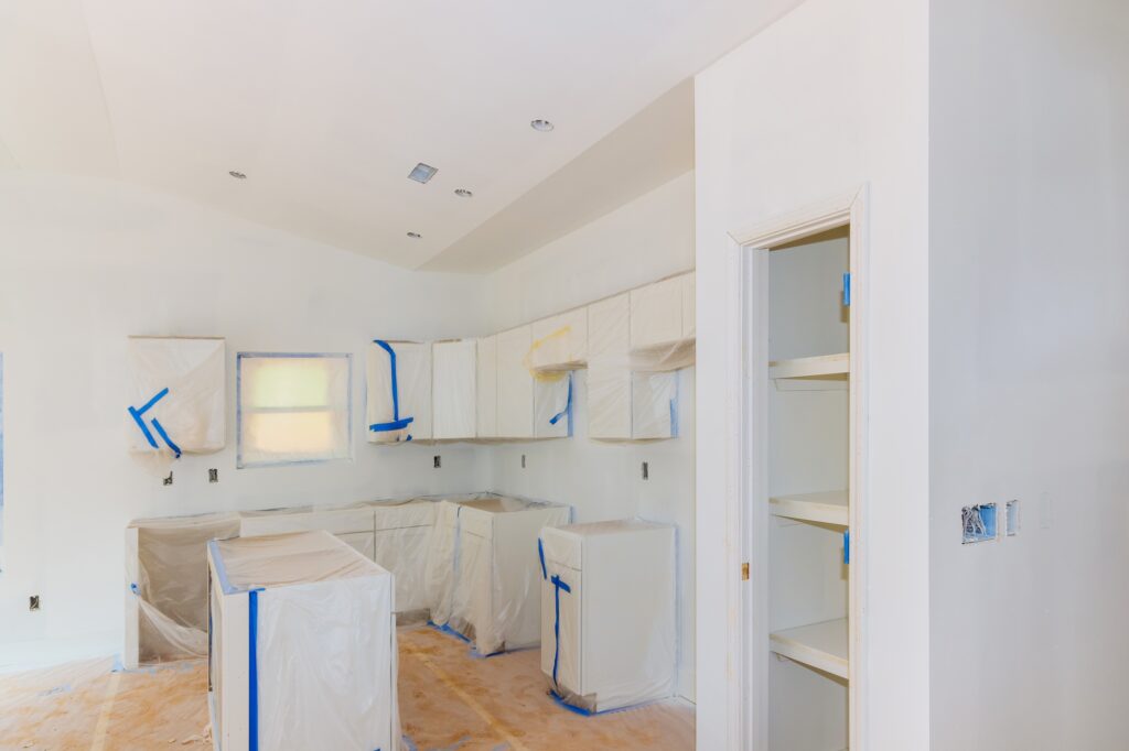 Finishing works in spray painting wall of a new kitchen
