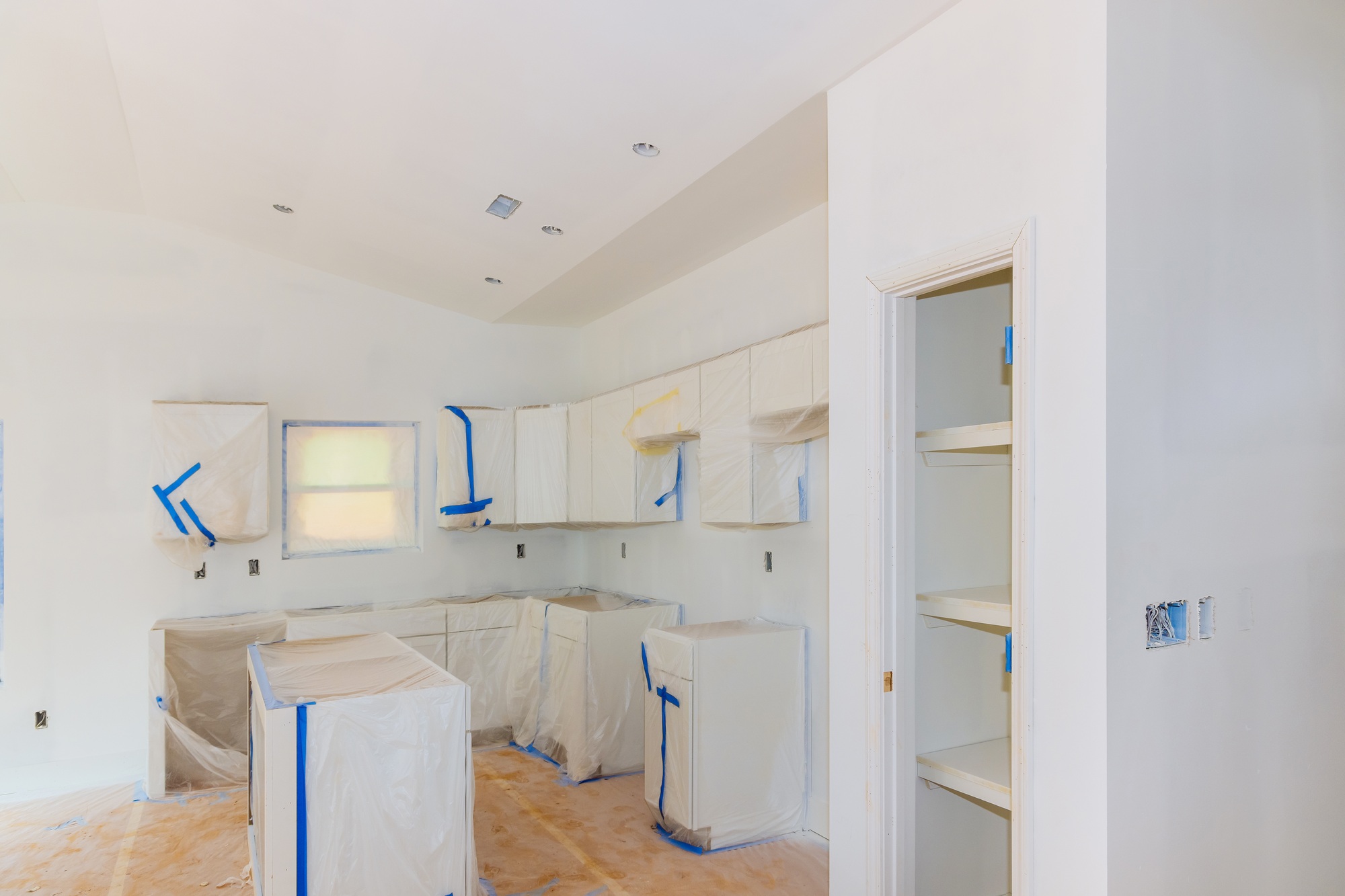 Finishing works in spray painting wall of a new kitchen