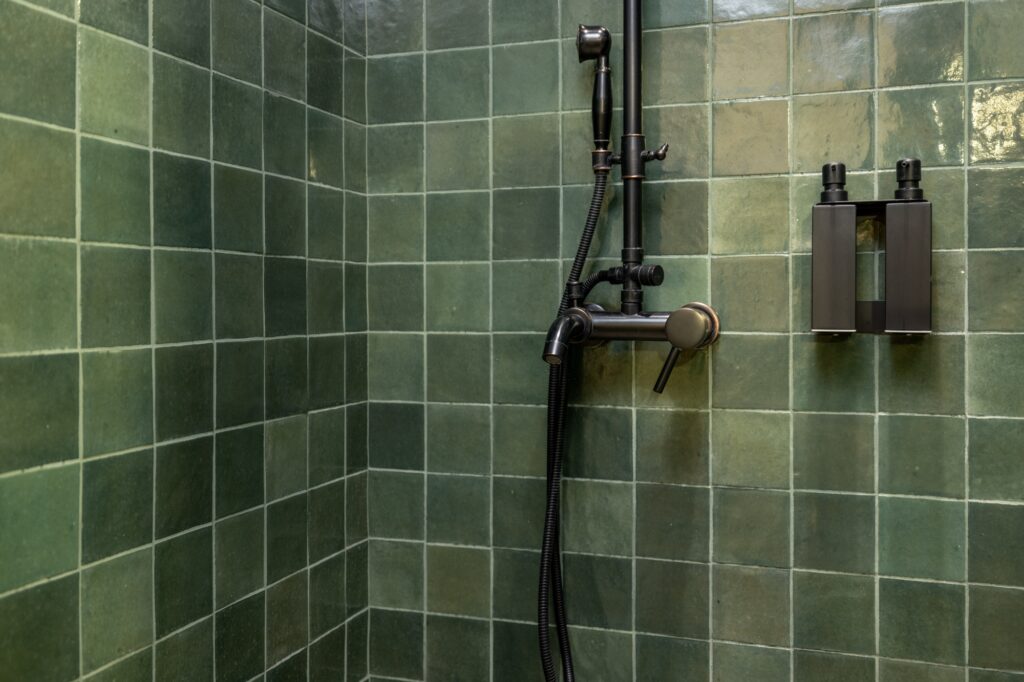 Green square bathroom tile and shower plumbing