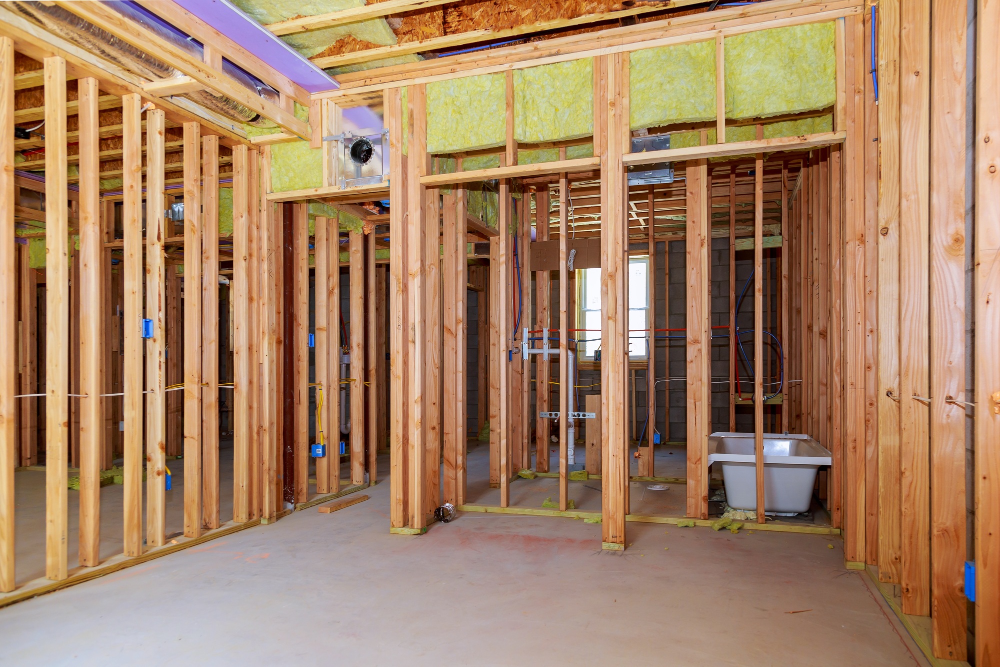 Interior wall framing with piping installation in the basement Bathroom remodel showing under floor