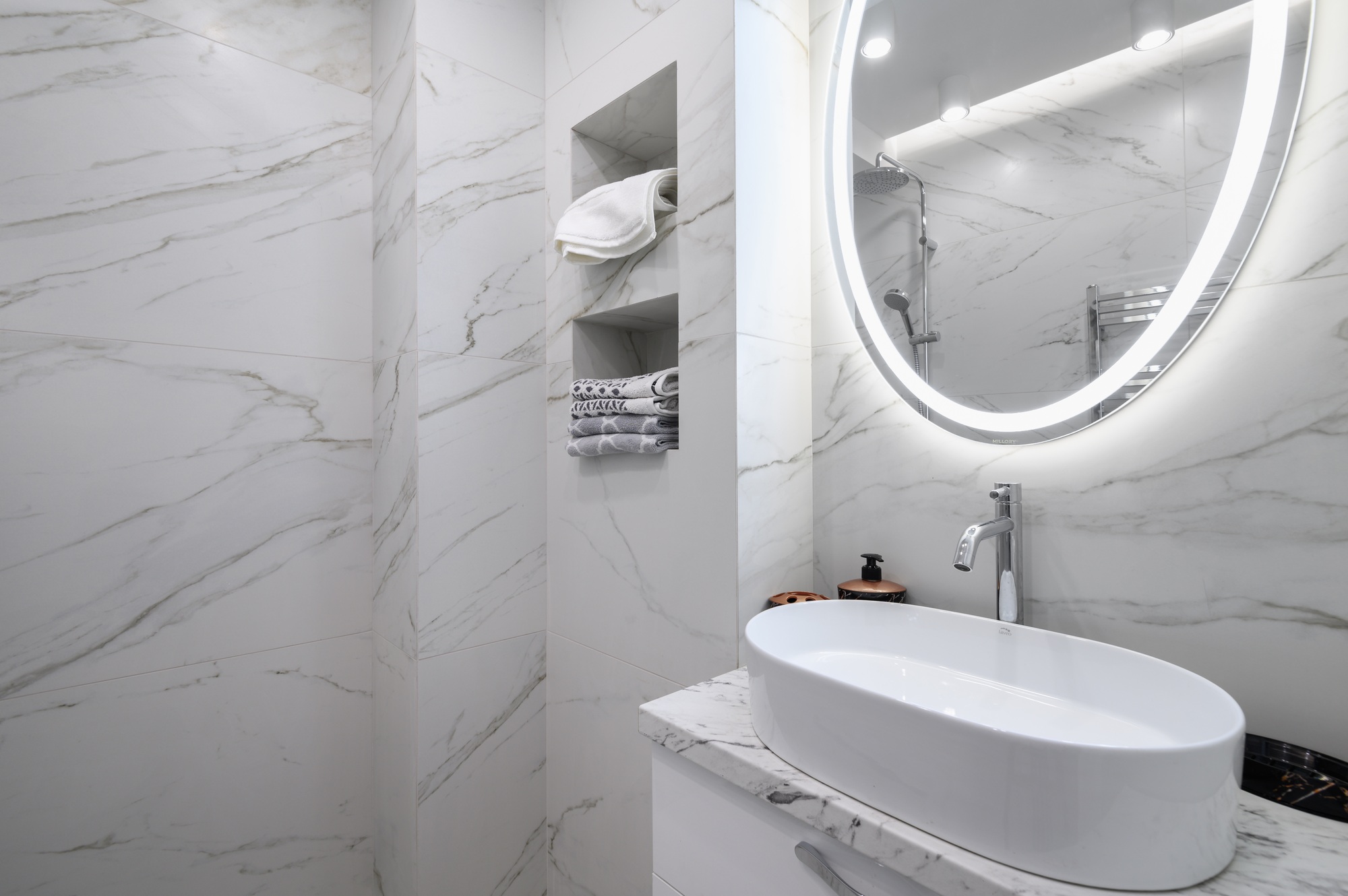White bathroom interior with marble tiles on the walls