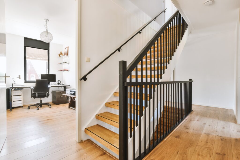 Wooden staircase in spacious hall of apartment
